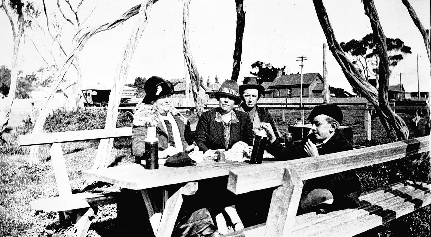 Семья за деревянным столом на пикнике в Морнингтоне, около 1928 года
